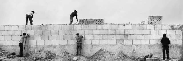 people building a wall together